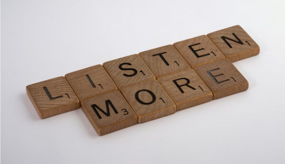 Scrabble block that spell LISTEN MORE